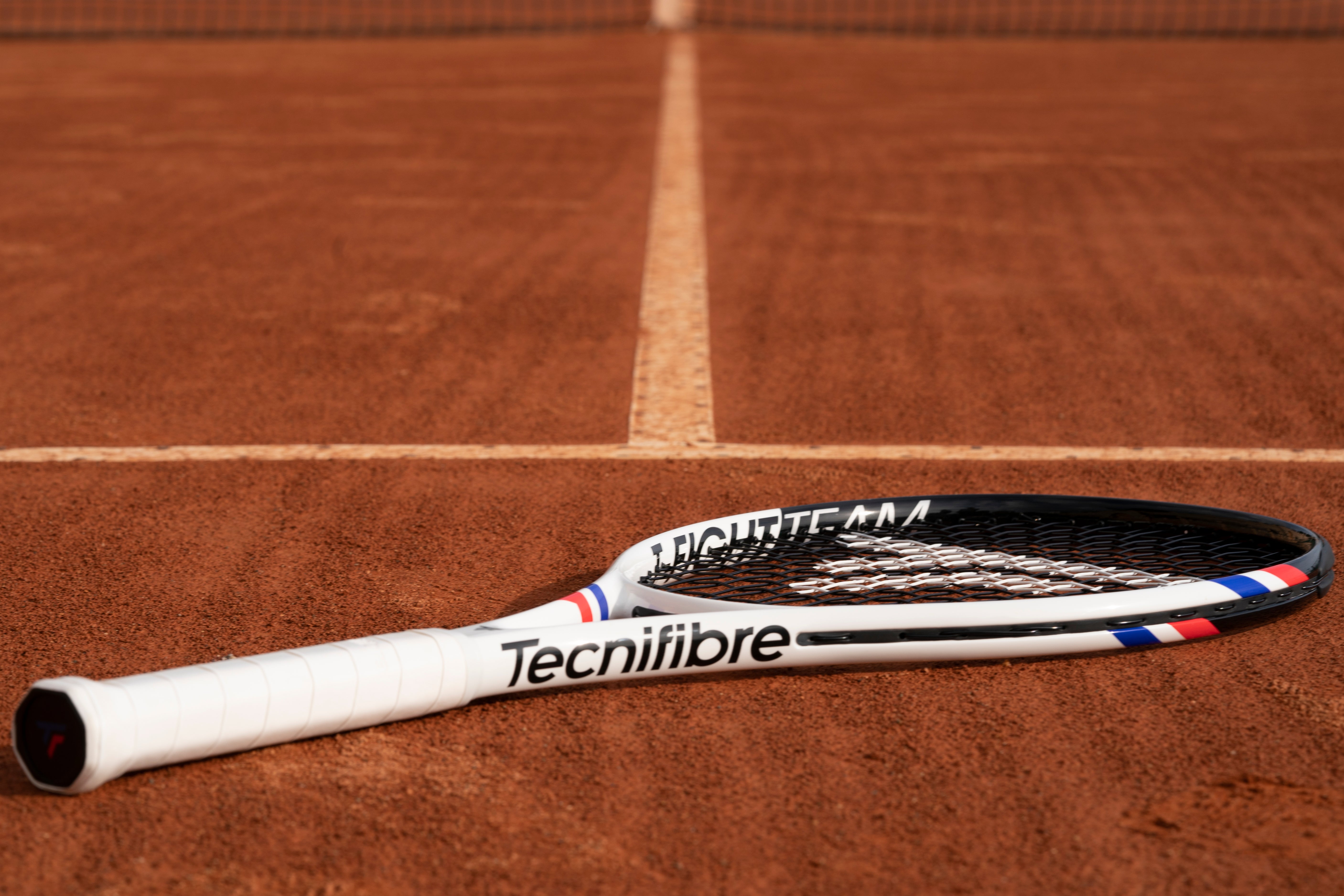Tecnifibre T-Fight racket lying on a clay court
